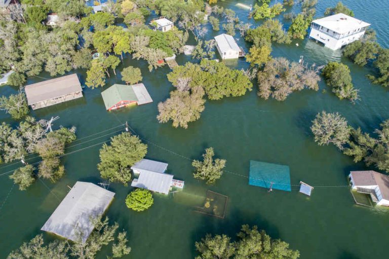 View of homes submerged in water after hurricane and storm flooding treetops and rooftops visible